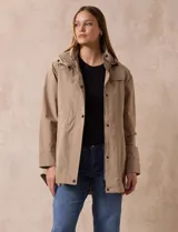 Campera impermeable color beige, marca Gallery. Tiene cierre oculto con botones a presión, bolsillos delanteros y capucha plegable en el cuello.