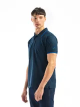 Remera polo verde con cuello y mangas con borde blanco, confeccionada en algodón.