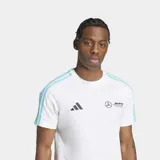 Remera blanca de algodón con cuello redondo y mangas cortas. Presenta tres tiras celestes en los hombros, logo de Adidas y logo de Mercedes AMG Petronas en el pecho.
