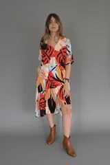 Vestido camisero midi con volados, estampado con hojas de colores y cierre frontal con botones.
