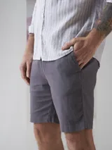 Bermuda gris de lino y algodón, corte recto y largo hasta la rodilla.