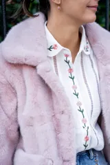 Camisa blanca de algodón con bordados de flores rosas en cuello, frente y puños, corte clásico y cierre con botones.