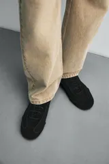 Zapatilla de cordones color beige, con capellada de cuero serraje, horma redonda y suela ultrafina.