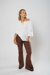 Blusa blanca de lino con corte asimétrico, mangas 3/4 con botones y cuello redondo amplio.