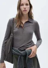 Polo gris de tejido de punto con cuello clásico, cierre de botones y mangas largas.