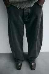 Pantalón de jean negro de corte amplio, estilo balloon fit, con cinco bolsillos y cierre frontal con botones.