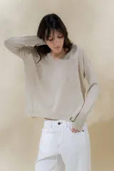 Sweater color beige de tejido de punto fino con brillo, escote en V y mangas largas.