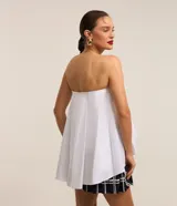Blusa sin breteles de tricolina blanca, con pliegue delantero y modelo amplio.