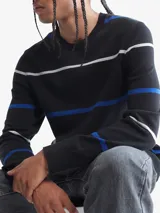 Sweater negro de algodón con rayas horizontales blancas y azules. Tiene cuello redondo y logo de Calvin Klein bordado en el pecho.