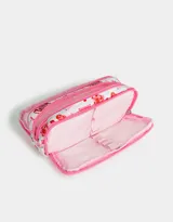 Cartuchera blanca con estampado de libros, bebidas y frases en tonos rosados. Tiene cierre circundante y tag frontal de silicona con la frase "I'm just a girl".