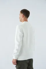 Buzo de algodón blanco con cuello redondo, manga larga y logo en relieve.