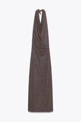 Vestido largo de fiesta confeccionado con hilo metalizado color marrón. Tiene cuello halter con lazada, escote drapeado, espalda descubierta con tira ajustable y cierre lateral con cremallera oculta.