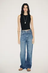 Pantalón de jean celeste de corte wide leg y tiro alto, con cinco bolsillos y cierre frontal con cremallera y botón metálico.