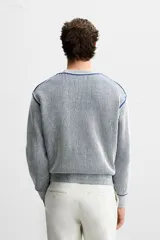 Jersey de punto con cuello redondo y manga larga. Diseño a rayas verticales en color azul marino y blanco.