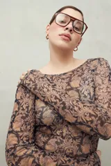 Top de manga larga en tejido translúcido con estampado animal print en tonos marrones y negros. Diseño ajustado con transparencia.