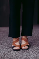 Sandalias de cuero color marrón con tiras cruzadas y taco bloque negro.