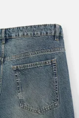 Pantalón cargo de denim color beige, corte relaxed fit, con bolsillos laterales tipo parche con solapa y cierre frontal con botones.
