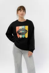 Buzo negro de algodón rústico con estampa frontal multicolor de labios. Corte relajado, cuello redondo y terminaciones en rib.