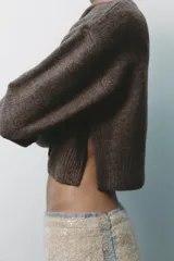 Chaqueta de punto color marrón con aberturas laterales y cierre frontal con botones.