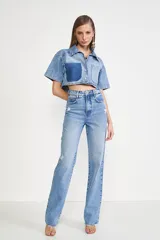 Pantalón de jean celeste de corte recto, tiro alto y con roturas en las rodillas.