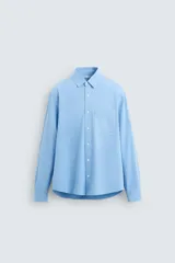 Camisa celeste de lyocell y algodón, corte relaxed fit, cuello solapa, manga larga con puño abotonado, bolsillo de parche en el pecho y cierre frontal abotonado.