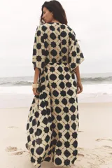 Vestido amplio estilo caftán con estampado geométrico en tonos beige y azul, escote en pico con lentejuelas y manga ancha por debajo del codo. Cintura ajustable con cordones con borlas.
