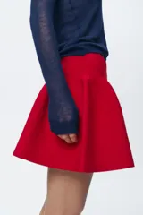 Falda mini roja de punto con cintura elástica y corte evasé.
