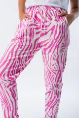Pantalón babucha con estampado de cebra en fucsia y blanco, de corte ajustado, cintura elástica y tejido liviano.