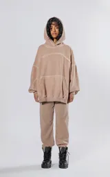 Buzo canguro beige con costuras expuestas, calce oversize, recortes y proceso batik artesanal. Confeccionado en frisa gamuzada.
