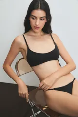 Conjunto de lencería negro con detalles de puntilla, compuesto por un corpiño sin aro y una tanga.
