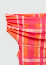 Top de mangas cortas con estampado de cuadros en tonos naranja y rosa, con cuello barco y hombro descubierto. Diseño crop y entallado de tejido elástico.