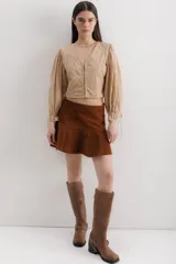 Minifalda marrón de cuero con volados en el ruedo.