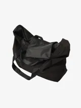 Bolso tote negro de Carhartt WIP, modelo Canby. Confeccionado en tafetán de nailon ligero, con compartimento principal con cierre de botón a presión, bolsillo interior con cremallera y bolsillo exterior. Asas de cincha resistentes y etiqueta cuadrada de Carhartt.
