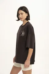 Remera marrón de corte holgado con estampado de una flor en el pecho.
