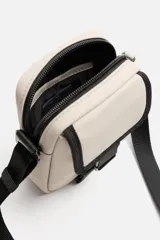 Bandolera vertical negra de acabado engomado con compartimento principal con cierre de cremallera y bolsillo interior plano. Bolsillo frontal con cierre de hebilla de liberación rápida. Asa de hombro ajustable y extraíble.