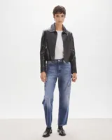 Campera de cuero negra, con corte ajustado y cierre frontal, diseño minimalista.