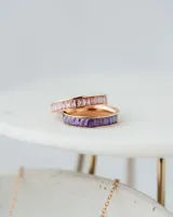 Anillo dorado con circonitas rosas rectangulares engarzadas en todo el contorno.