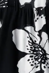 Vestido camisero midi de viscosa con estampado floral en blanco y negro, cuello camisero, tapeta de botones oculta, mangas raglán largas con puños sencillos y costuras fruncidas en la pollera.