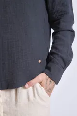 Camisa de manga larga color gris oscuro, con cuello clásico y cierre frontal con botones.