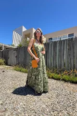 Vestido largo verde con estampado abstracto en blanco y negro, de fibrana, con breteles finos y volado en el ruedo.