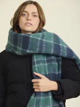 Bufanda larga con diseño tartán en tonos verde, azul y blanco.