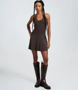 Vestido sin mangas de corte evasé, color verde oliva, con escote redondo y detalle de lazo en el cuello. El tejido presenta un efecto tricot texturizado acanalado.