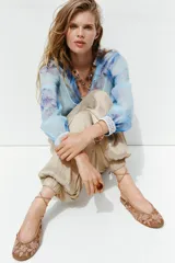 Pantalón bombacho color beige de tiro alto, con elástico en la cintura y en los tobillos.