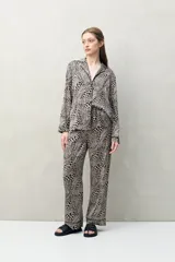 Pantalón de pijama de fit relajado con estampado animal print en tonos beige y negro. Cuenta con cintura elastizada y un calce fluido.