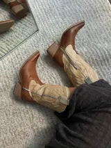 Bota texana de cuero color marrón, con caña media, punta fina y taco de madera.
