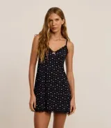 Camisón corto de microfibra color negro con estampado de brillos plateados, breteles finos ajustables y detalle de encaje negro en el escote y ruedo.