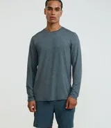 Remera deportiva de manga larga para hombre, color gris azulado jaspeado, con cuello redondo y costuras visibles en hombros y cuello.