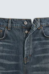 Pantalón de jean azul con efecto lavado, corte recto y largo al tobillo.