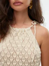 Top de punto color crema, con cuello halter y tiras finas para atar en el cuello.