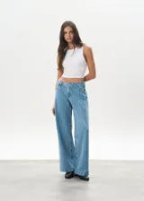 Pantalón de jean celeste con rayas verticales, tiro bajo y corte wide leg.